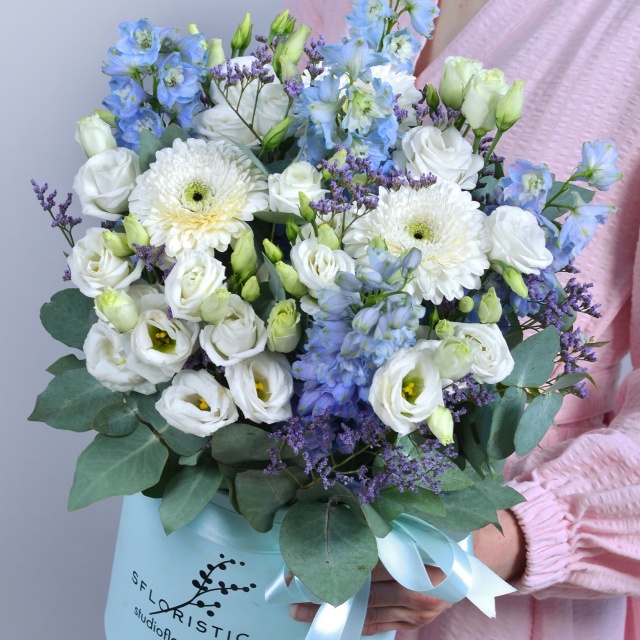 Композиция из Эустомы, Дельфиниума в шляпной коробке «Нежность неба» Композиция из Эустомы, Дельфиниума в шляпной коробке «Нежность неба»